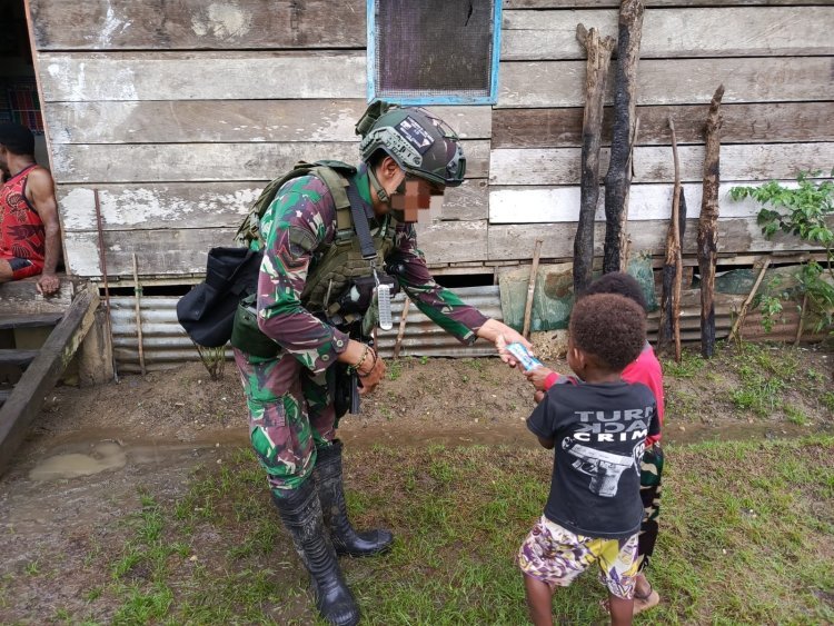 Bagi Susu Kepada Warga Kuari, Satgas Marinir Disambut Gembira